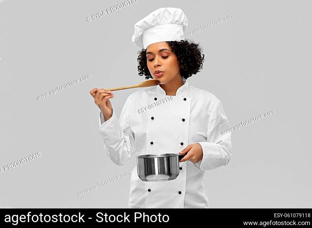 female chef with saucepan and spoon cooking food