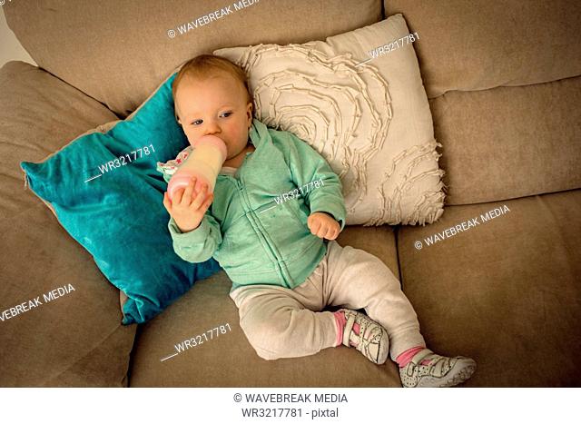 Baby girl drinking milk from baby bottle