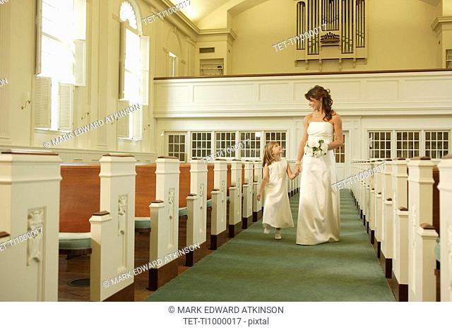 Bride walking down aisle with flower girl