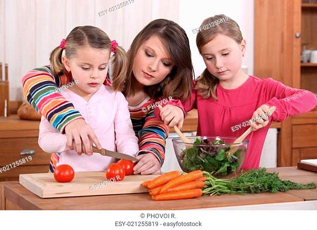 Mother teaching her daughters how to cook