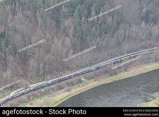 14 April 2021, Saxony, Königstein: A freight train passes through Königstein on the railway line along the river Elbe. Photo: Robert Michael/dpa-Zentralbild/ZB