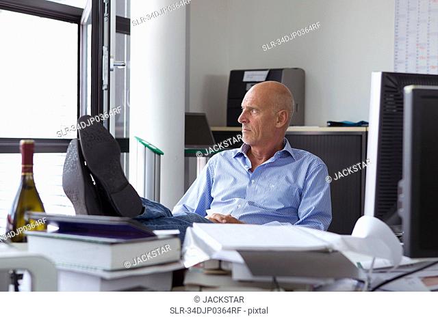 Businessman relaxing with feet on desk