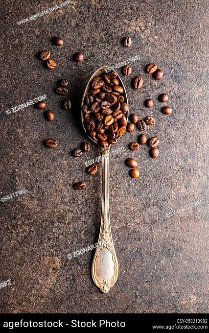 Roasted coffee beans in spoon. Top view