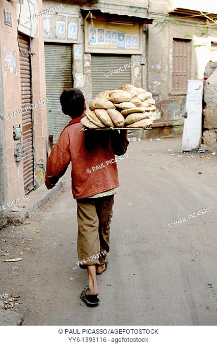 delivery boy carrying egyptian bread eesh baladi , islamic cairo , backstreet life , cairo , Egypt