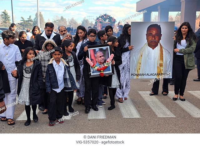 CANADA, MISSISSAUGA, 08.11.2015, Tamil Hindu mourners carry photos of the deceased as they escort his coffin during a funeral procession on route to a...