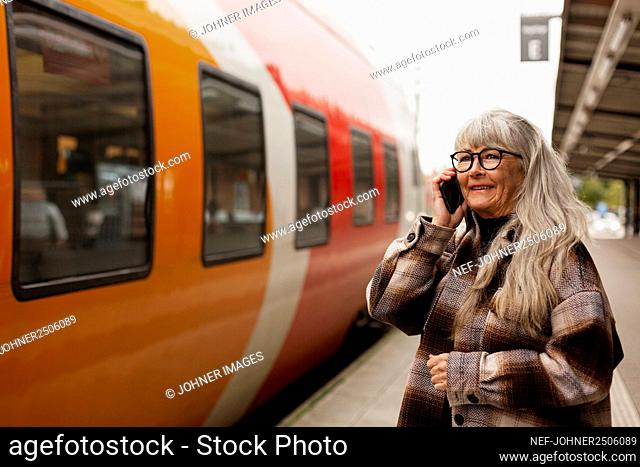 Mature woman on the phone at train station