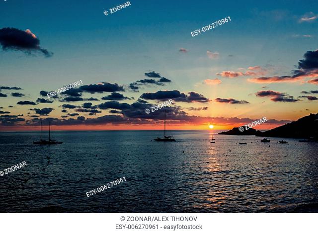 Magnificent sunset above the Mediterranean Sea and sailboats silhouette. Ibiza, Spain