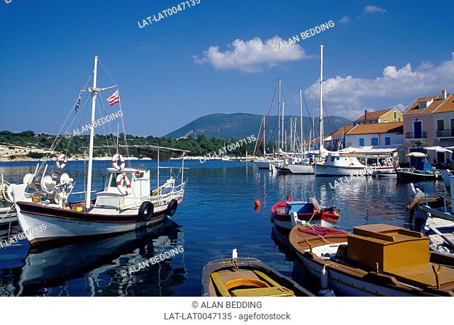 Cephallonia. Ionian islands. Fishing boats. Yachts. Moored. Castle across channel