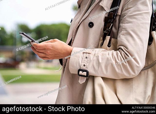 Medium shot of woman's hands holding a cell phone