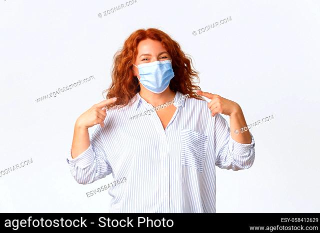 Covid-19 social distancing, coronavirus preventing measures and people concept. Cheerful smiling redhead middle-aged woman staying protected from virus