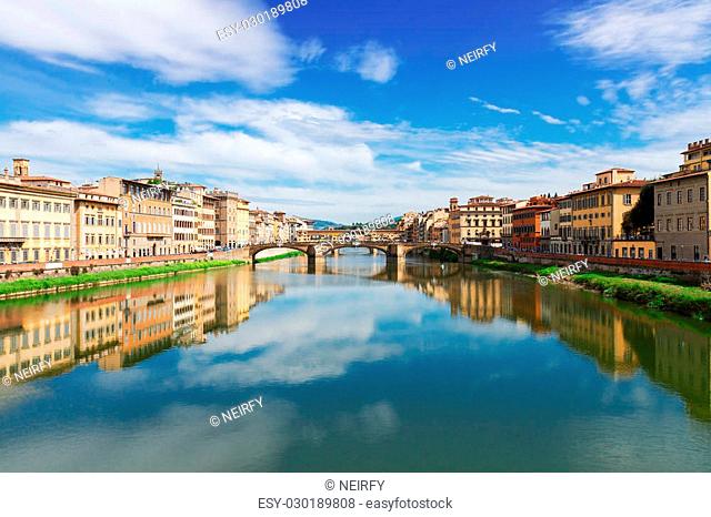 famous Triniti and Ponte Vecchio bridges reflecting in river Arno at summer day, Florence, Italy