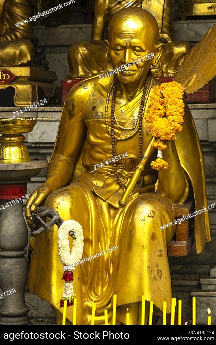 Realistic golden monk statue at the sacred site of Wat Phra That Doi Suthep Buddhist temple in Chiang Mai Province, Thailand