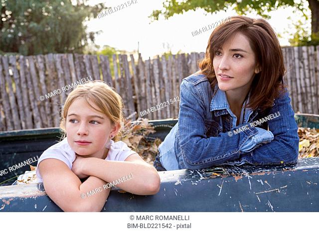 Mother and daughter sitting in truck bed