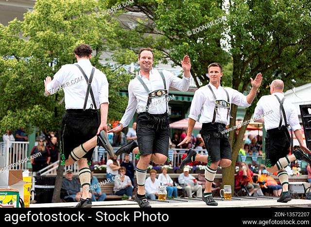 Frankenmuth, Michigan, USA - June 10, 2018 Men and women playing traditional german music drinking beer dancing and wearing traditional german clothing at the...