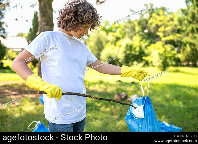 Volunteer. Cute young volunteer cleaning the park from plastic garbage