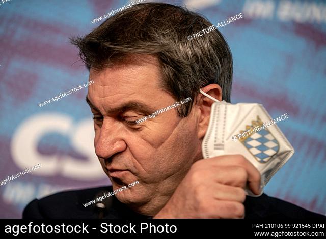 dpatop - 06 January 2021, Berlin: Markus Söder (CSU), Prime Minister of Bavaria and CSU chairman, takes off his mask during the press conference at the winter...