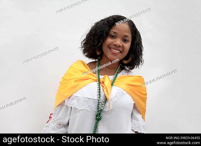 Portrait of smiling young woman wearing traditional clothing from the Caribbean, studio shot