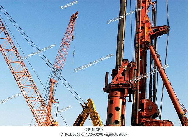 Piler and various crane arms on a construction site, London, UK