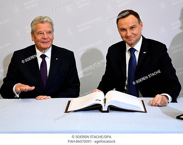 German President Joachim Gauck (l) and Polish President Andrzej Duda sign the guest book during a visit to the multi-national corps North/East of the NATO in...