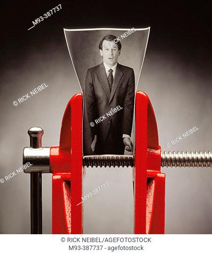 B/W photo of business man; photo in red vise as though the man were being squeezed. Man looks distressed