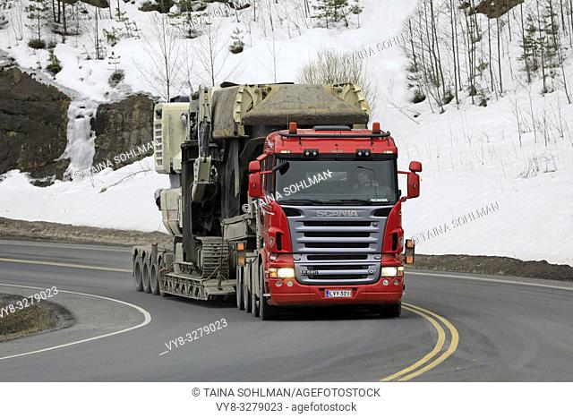 Forssa, Finland - March 30, 2019: Scania R620 semi of Veljekset Makitalo Oy hauls Metso Lokotrack crusher on low loader trailer on road in the spring