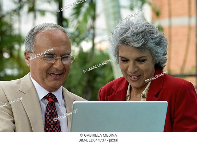 Senior Hispanic couple looking at laptop