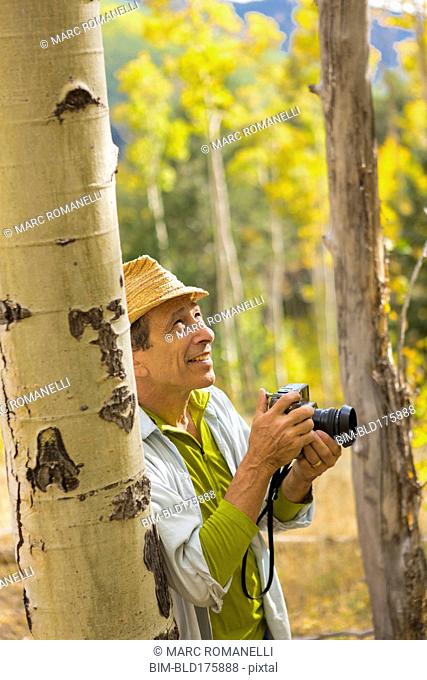 Man photographing with camera in autumn forest