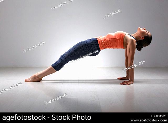 Beautiful sporty fit yogini woman practices Ashtanga Vinyasa yoga asana Purvottanasana, upward-facing plank full pose