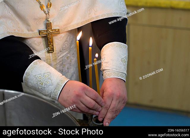 The rite of baptism. Priest prepare to baptize the child. Font for taking faith.The hands of the priest near the Epiphany bath