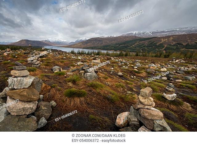 Mountains in the Highlands of Scotland with Loch Loyne, snow and piles of stone