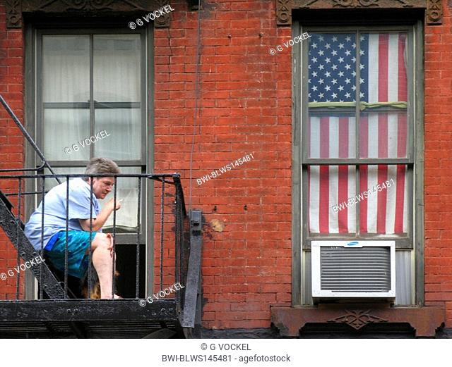 woman smokes a cigarette on balkony, USA, Manhattan, New York