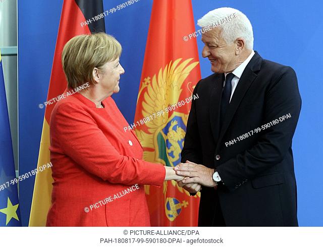 17 August 2018, Germany, Berlin: Federal Chancellor Angela Merkel (CDU) welcomes Dusko Markovic, Prime Minister of Montenegro in front of the Federal...