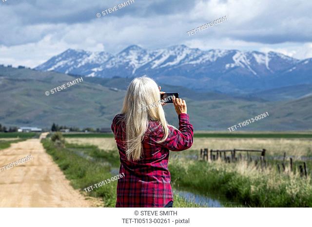 Woman photographing mountains in Fairfield, Idaho, USA