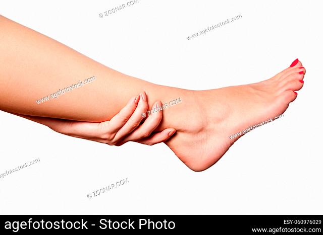 Closeup view of a young woman with pain on leg on white background