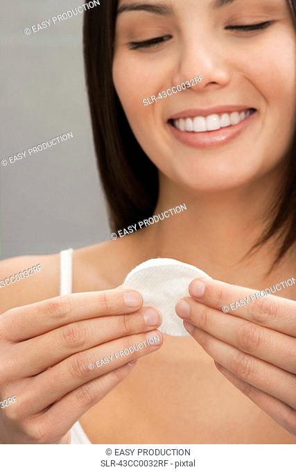 Smiling woman holding cotton pads