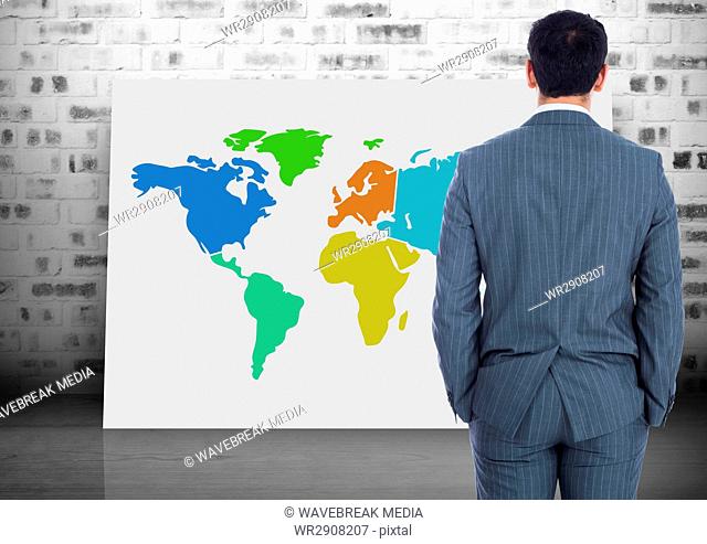 Businessman looking at Colorful Map with brick wall background