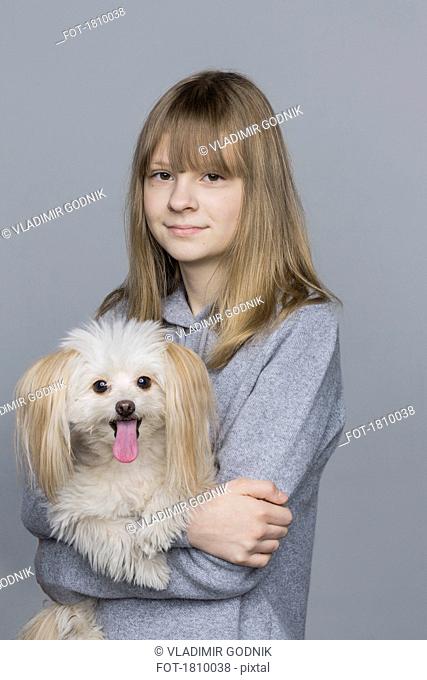 Portrait smiling tween girl holding dog