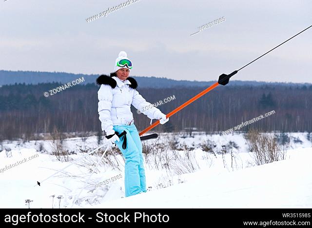 woman in a white jacket on a ski mountain resort rises on a lift