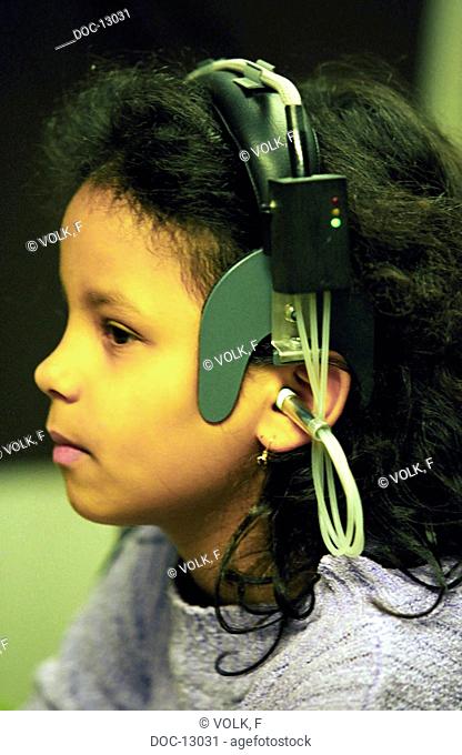 Portrait - Pre-teen girl subjects herself to a listening test