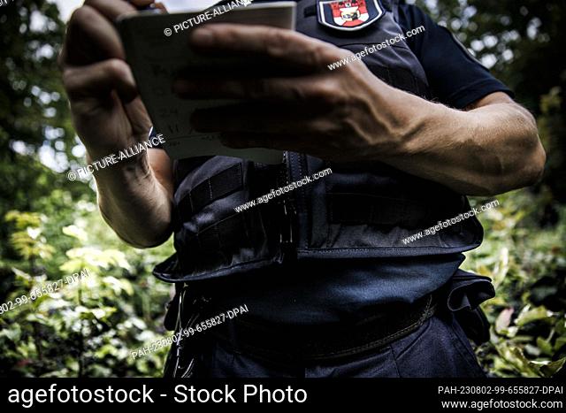 PRODUCTION - 01 August 2023, Berlin: An employee of the public order office writes notes in a pad during a control in Weinbergspark