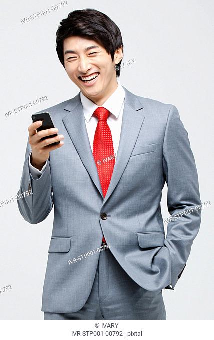 Laughing Asian Businessman Using Cell Phone