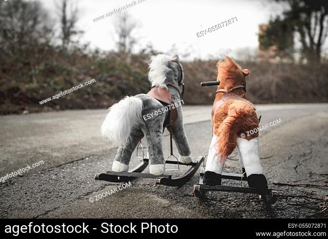 Abandoned rocking horses on the road. Concept of abandonment, loneliness, the end of childhood