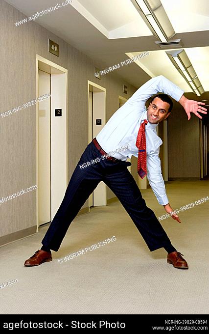 Office worker stretching in corridor