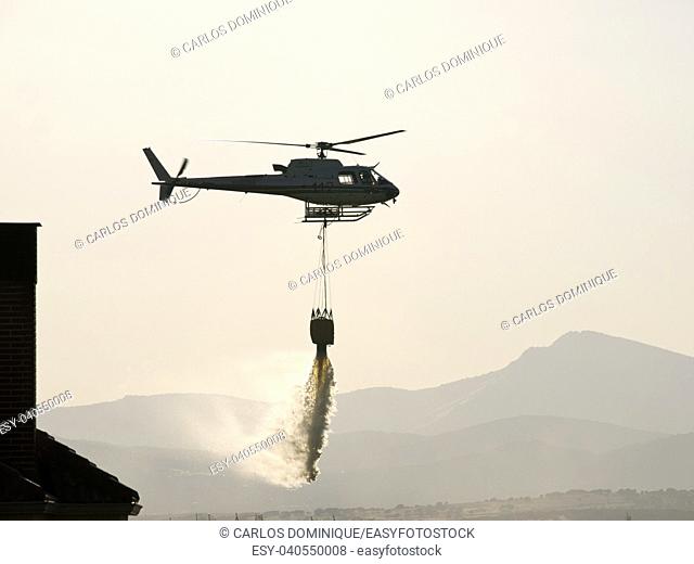 fire fighter helicopter dropping water in a fire