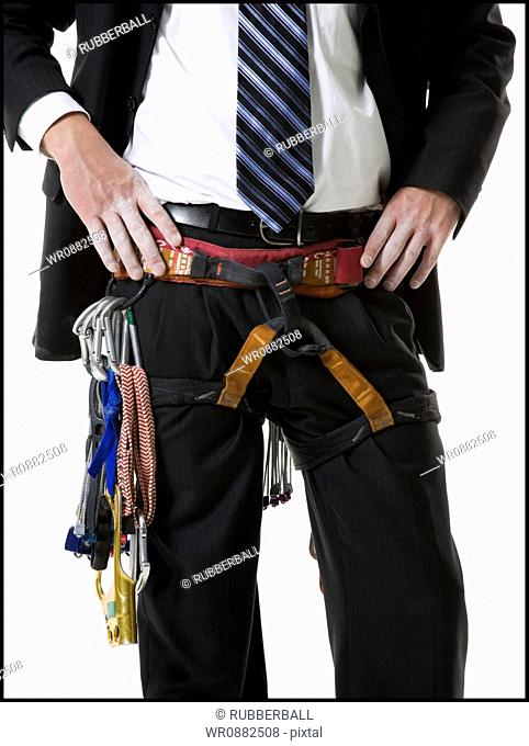 Mid section view of a young man wearing a harness around his waist
