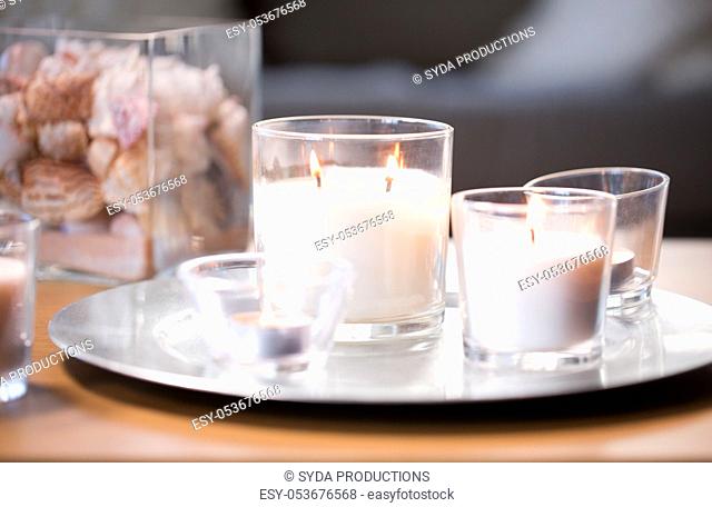 burning white fragrance candles on tray on table