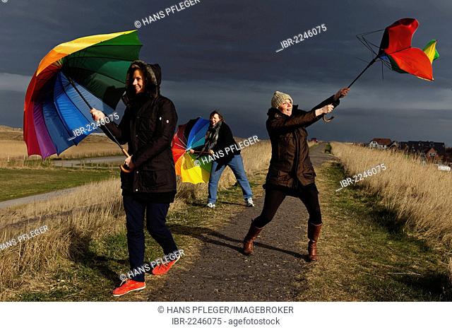 Three women holding umbrellas, stormy weather, Sankt Peter-Ording, Schleswig-Holstein, Germany, Europe
