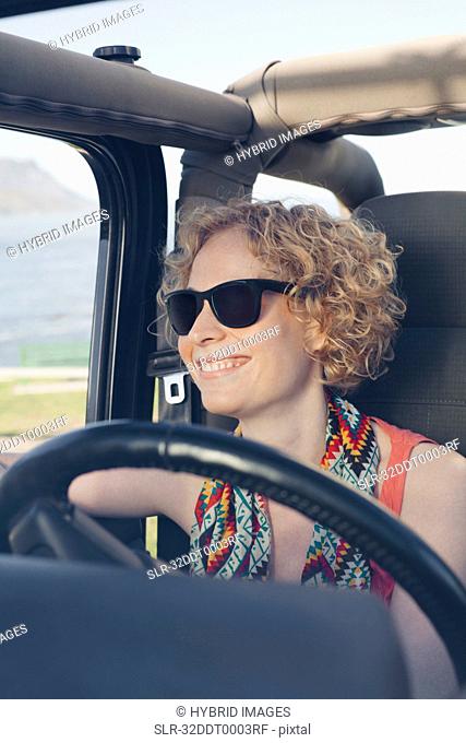 Smiling woman driving jeep