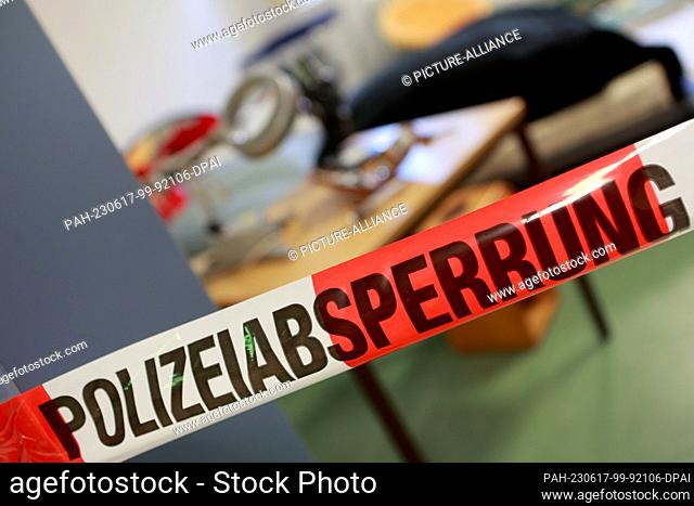 17 June 2023, Saxony-Anhalt, Aschersleben: A barrier tape with the inscription police cordon is stretched in front of a sample crime scene