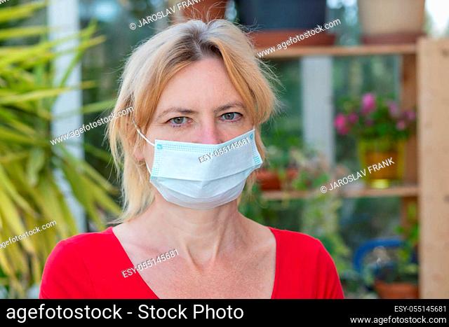 Portrait od woman with disposable protective face mask closeup. Horizontally
